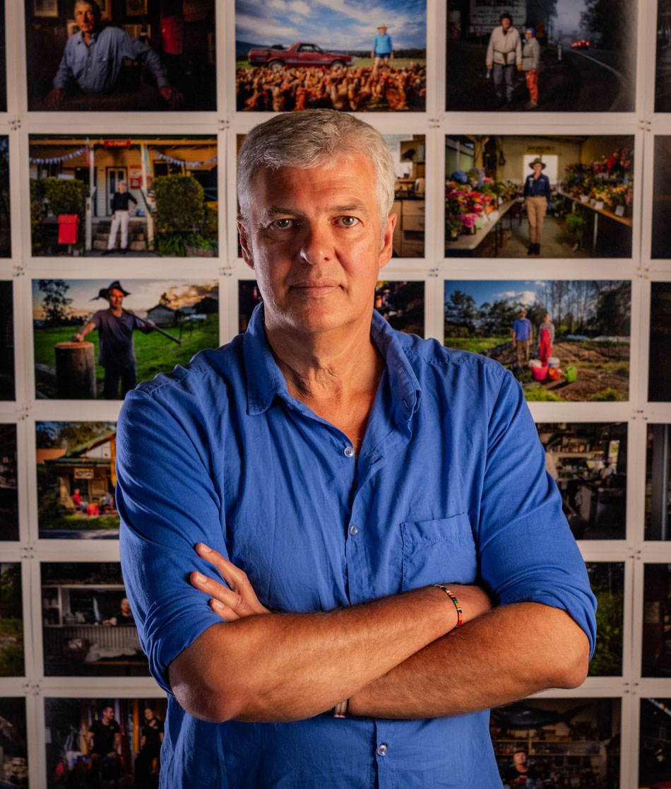 Ian Darling in front of wall of photos